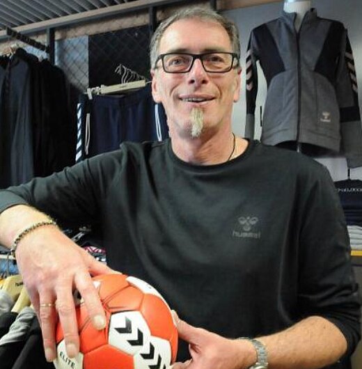 Inhaber Frank Strunk mit einem Handball in seinem Sportgeschäft in Werther